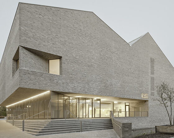 Moderne Architektur eines Ziegelbaus mit klaren Linien und großen Fenstern.