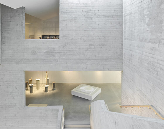 Moderne Architektur mit Betonwänden und minimalistischer Innenausstattung in einem hellen Raum.