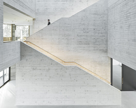 Moderne Treppenhausarchitektur mit Betonwänden und minimalistischen Designelementen.