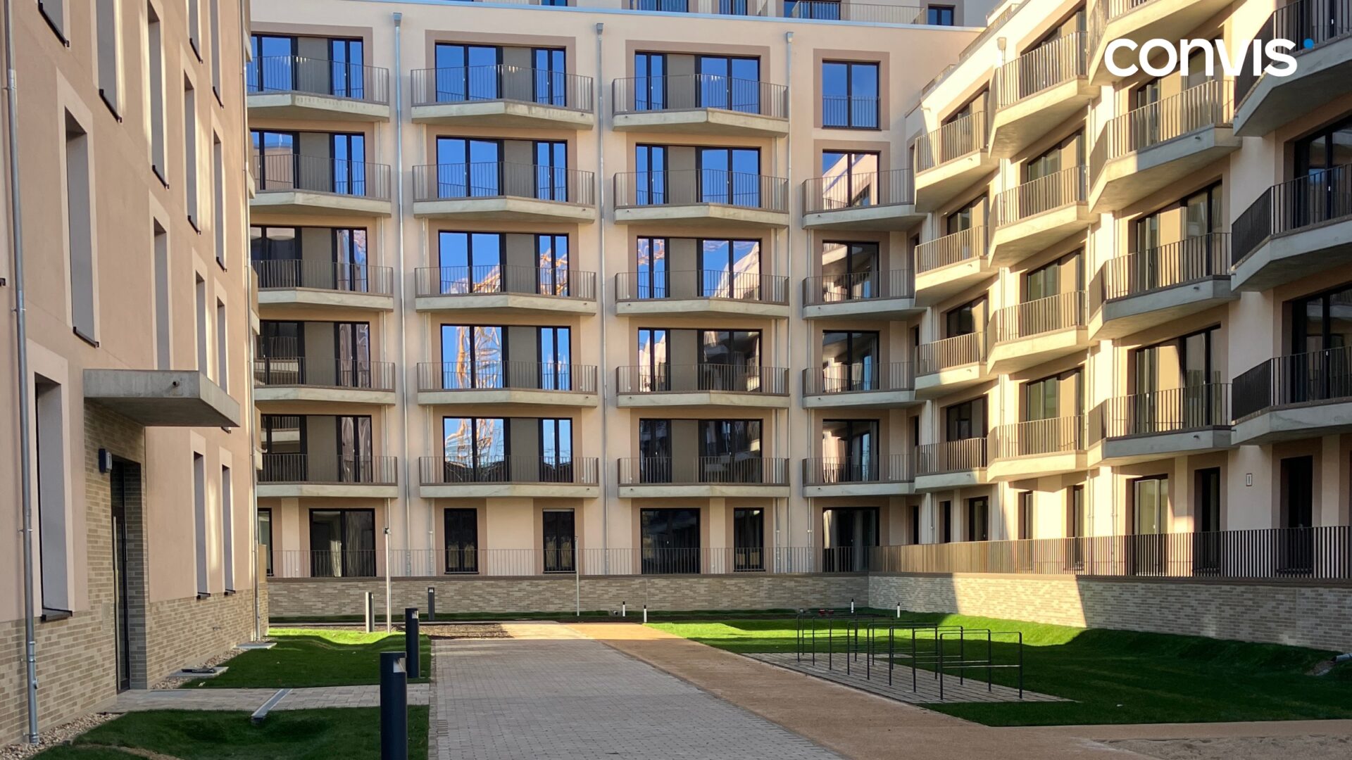 Moderne Wohnanlage mit Balkonen und gepflegtem Grünbereich im Innenhof.