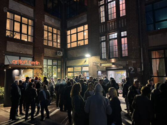 Vielbesuchte Kunstveranstaltung vor dem Artloft Berlin in einer lebhaften Nacht.