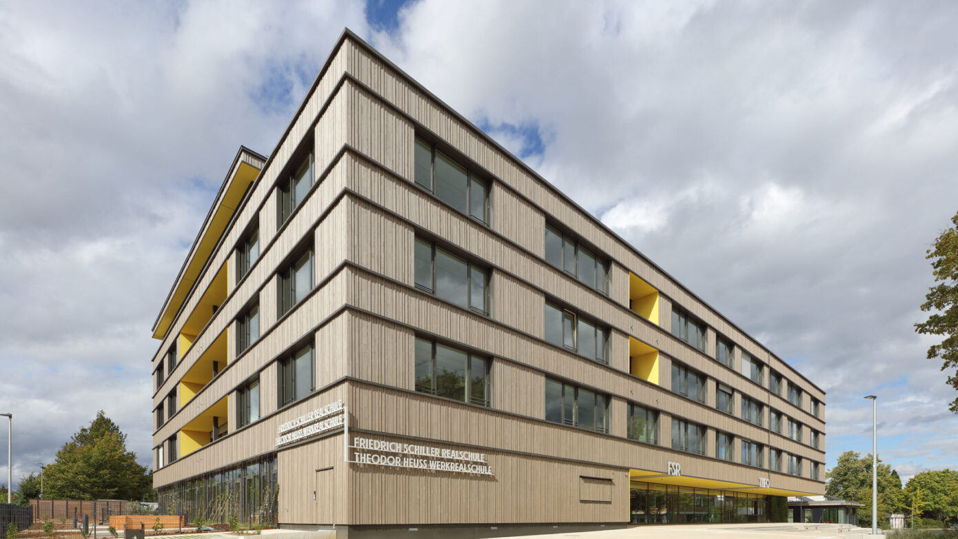 Ansicht des Eingangsbereichs der Friedrich-Schiller-Realschule und Theodor-Heuss-Werkrealschule in Stockbrünnle, Böblingen, mit großen Fenstern und Holzfassade.