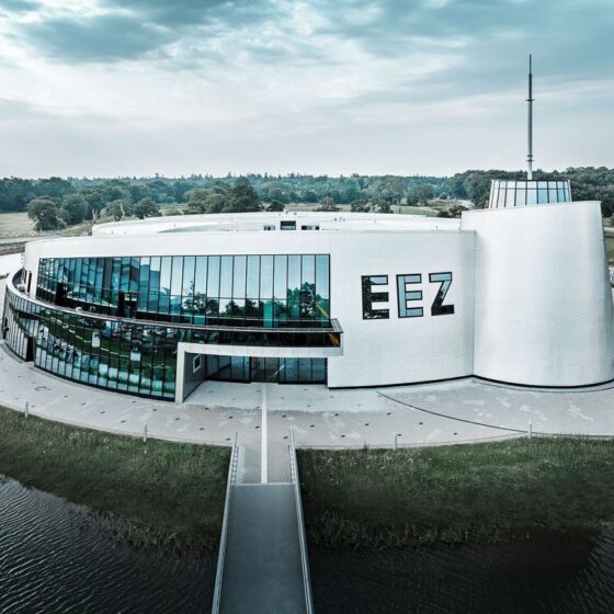 Moderne Architektur des EEZ mit Glasfassade und umliegendem Wasser.