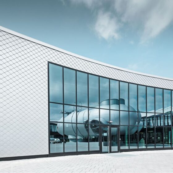 Moderne Architektur mit geschwungener Glasfassade und futuristischem Gebäudedesign.