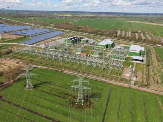 Ansicht BorWin6 mit Windkraft, Solarpanelen und Hochspannungsleitungen in ländlicher Umgebung.