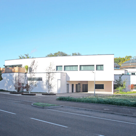 Mineraltheme Böblingen von Außen mit moderner Architektur eines weißen Gebäudes an einer ruhigen Straße mit grünem Umfeld.