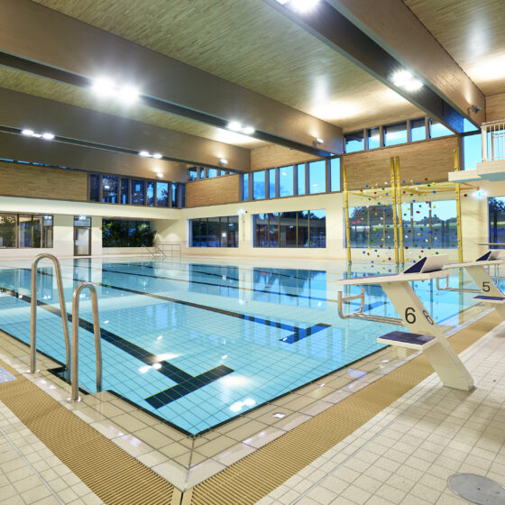 Familienbad Delfinoh von innen mit einem hellen Schwimmbad mit Schwimmbahnen und großen Fenstern für Tageslicht.