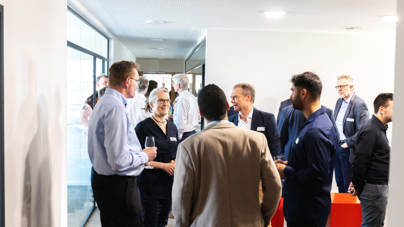 Networking-Event mit Fachleuten in modernem Büroambiente, angeregte Gespräche und Austausch.