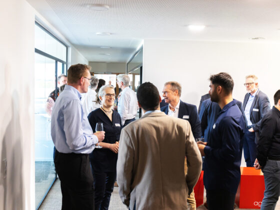 Networking-Event mit Fachleuten in modernem Büroambiente, angeregte Gespräche und Austausch.