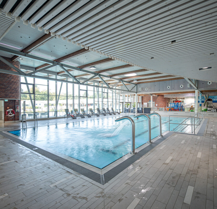 Modernes Hallenbad mit großzügigem Schwimmbecken und lichtdurchflutetem Ambiente.