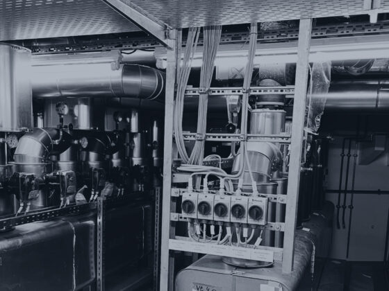 Industrielle Maschinen und Rohre in einem modernen Fertigungsraum.