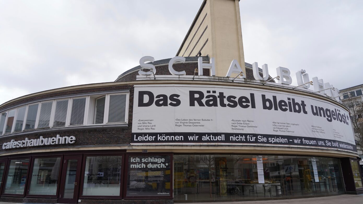 Gebäuder des Theaters Schaubühne Berlin: Plakat mit dem Text "Das Rätsel bleibt ungelöst" am Gebäude.