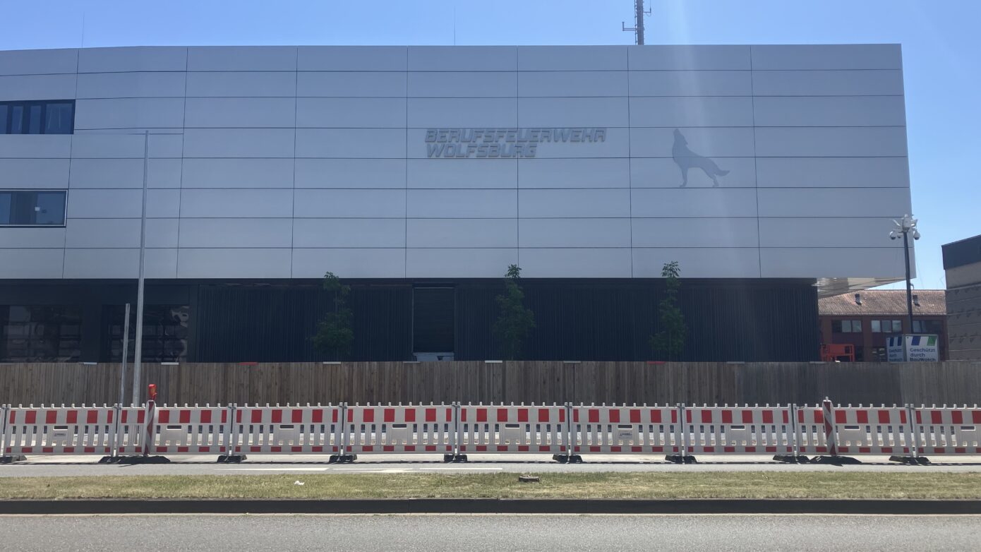 Moderne Fassade des Unternehmens "Belfra", Baustelle mit Absperrungen im Vordergrund.