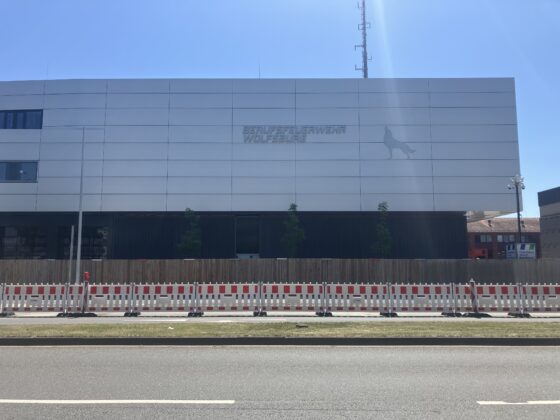 Moderne Fassade des Unternehmens "Belfra", Baustelle mit Absperrungen im Vordergrund.