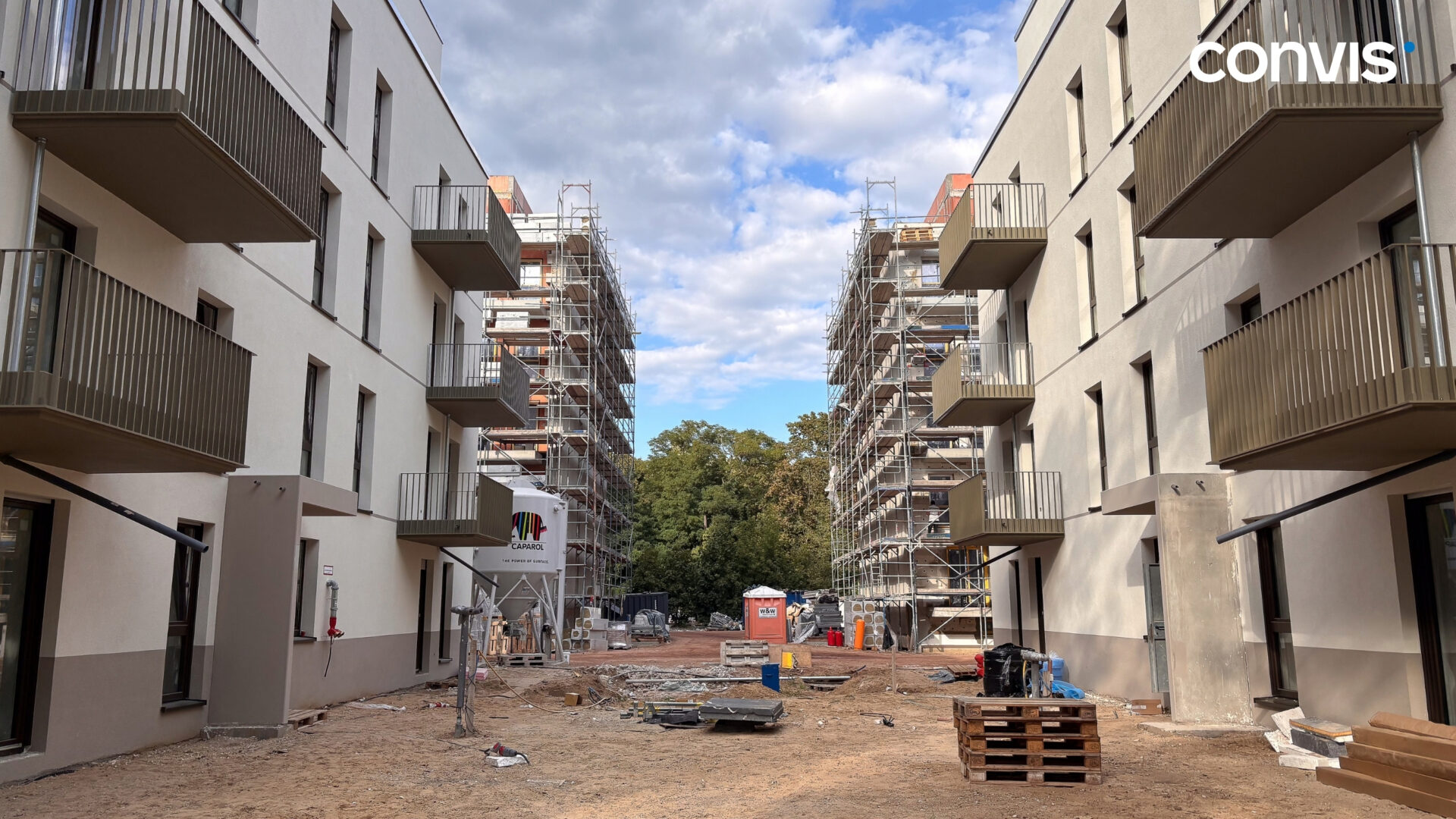 Bauprojekt mit modernen Wohngebäuden und Baustelle in städtischer Umgebung.