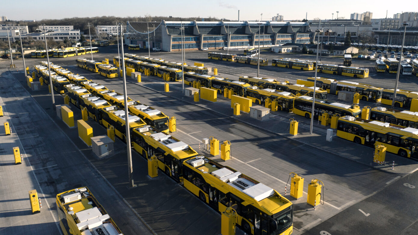 Gelbe Busse in einem modernen Depot mit klarer Anordnung und Sonnenlicht.