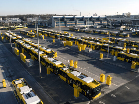 Gelbe Busse in einem modernen Depot mit klarer Anordnung und Sonnenlicht.