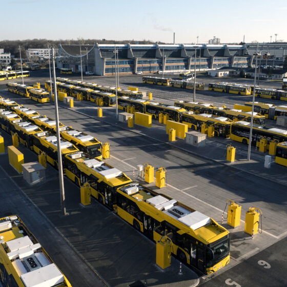 Gelbe Busse in einem modernen Depot mit klarer Anordnung und Sonnenlicht.